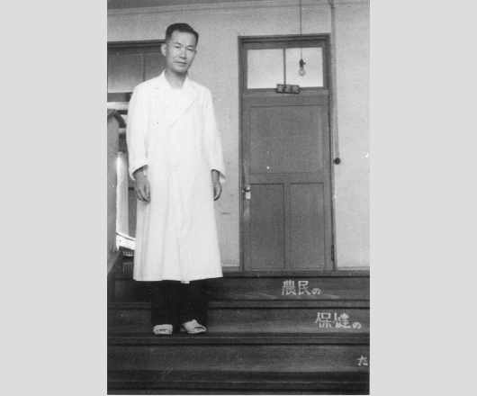 当時の院長室(2階)の前で。階段には「農民の保健のために」と書いてある。(昭和26年)